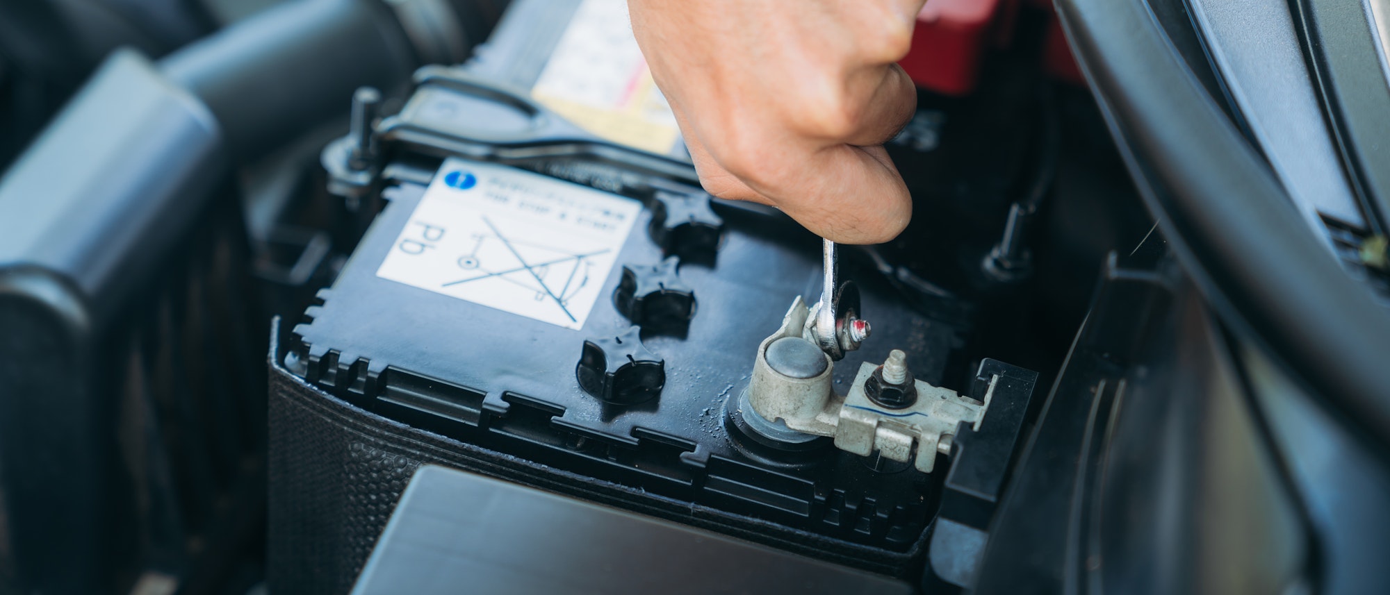 A man is maintenance on his car, checking and change the battery. Car maintenance concept.